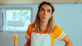 Femme tient rouleau de peinture