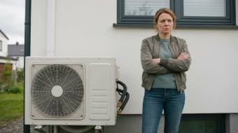 une femme mecontente devant sa pompe a chaleur